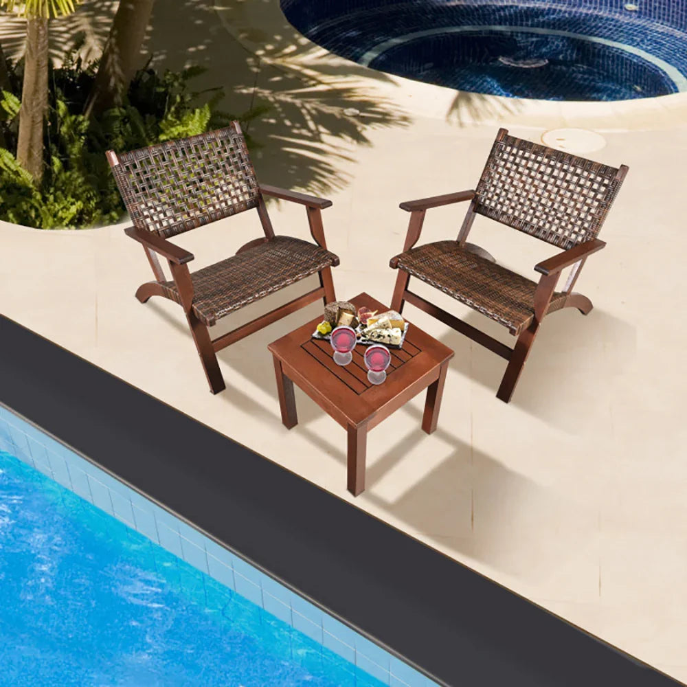 Two brown woven outdoor lounge chairs and wooden table by a pool with drinks and snacks