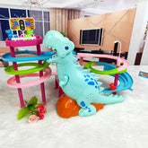 Light blue dinosaur toy with blue spots and a multi-color spiral racetrack on white carpet