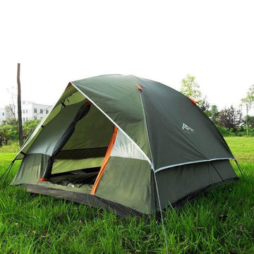 Olive green dome tent with orange accents, waterproof fabric, set up on grass outdoors