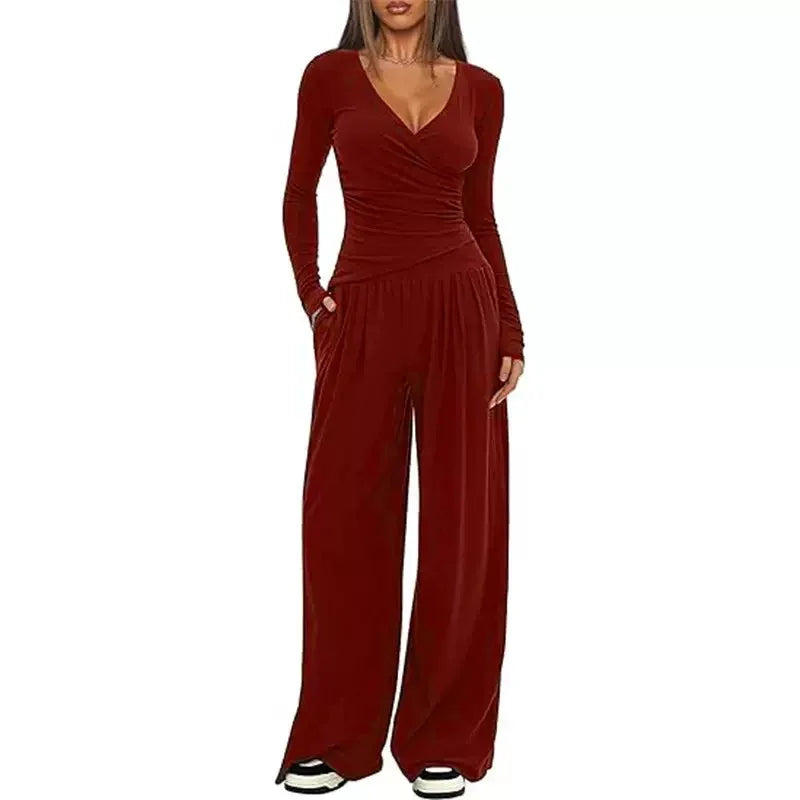 Woman wearing burgundy velvet wide-leg jumpsuit with long sleeves and a fitted wrap top.