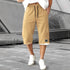 Beige knee-length streetwear shorts with black drawstring, relaxed fit, and white sneakers