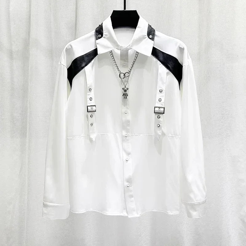 White long sleeve shirt with black faux leather shoulder panels, metal buckles, and silver chain.