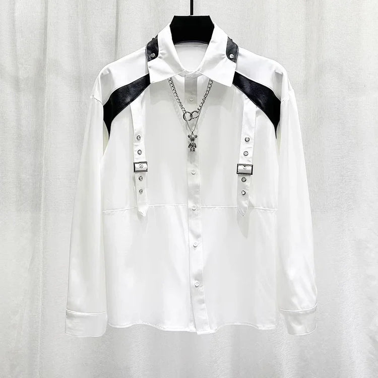 White long sleeve shirt with black faux leather shoulder panels, metal buckles, and silver chain.