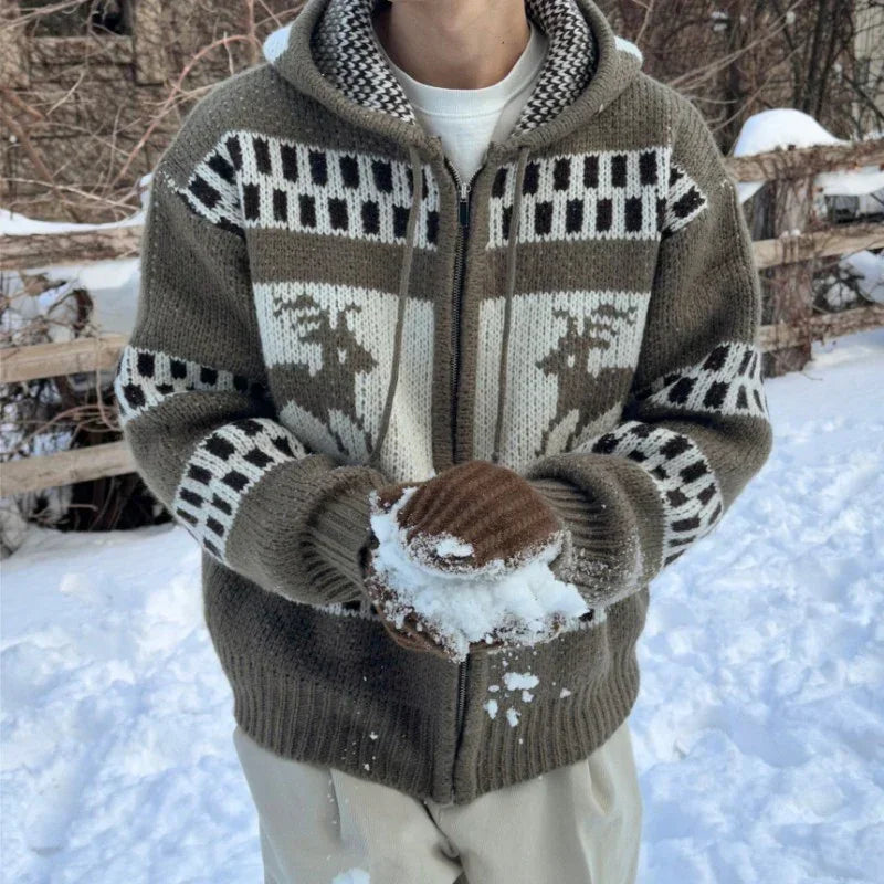 Man wearing thick knit zip-up sweater with reindeer pattern, neutral tones, relaxed fit, in snow.