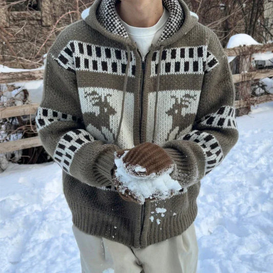 Man wearing thick knit zip-up sweater with reindeer pattern, neutral tones, relaxed fit, in snow.