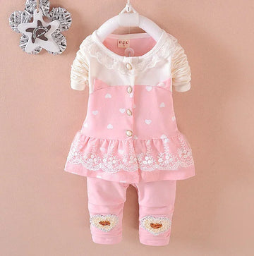 Pink and white baby girl outfit with heart patterns, lace trim, ruffled skirt, and leggings