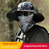 Man wearing black solar-powered fan hat, graphic bandana face mask, and dark outdoor clothing