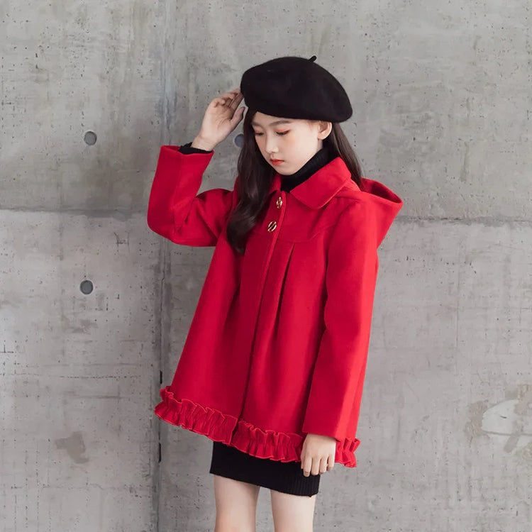 Girl in a red wool coat with ruffle hem and black beret, urban background