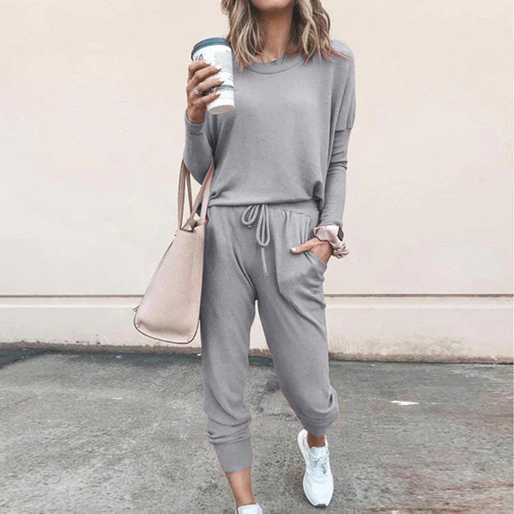 Woman in a light gray casual loungewear set with jogger pants, relaxed fit, soft fabric.