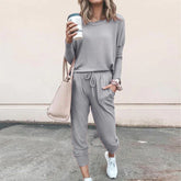 Woman in a light gray casual loungewear set with jogger pants, relaxed fit, soft fabric.