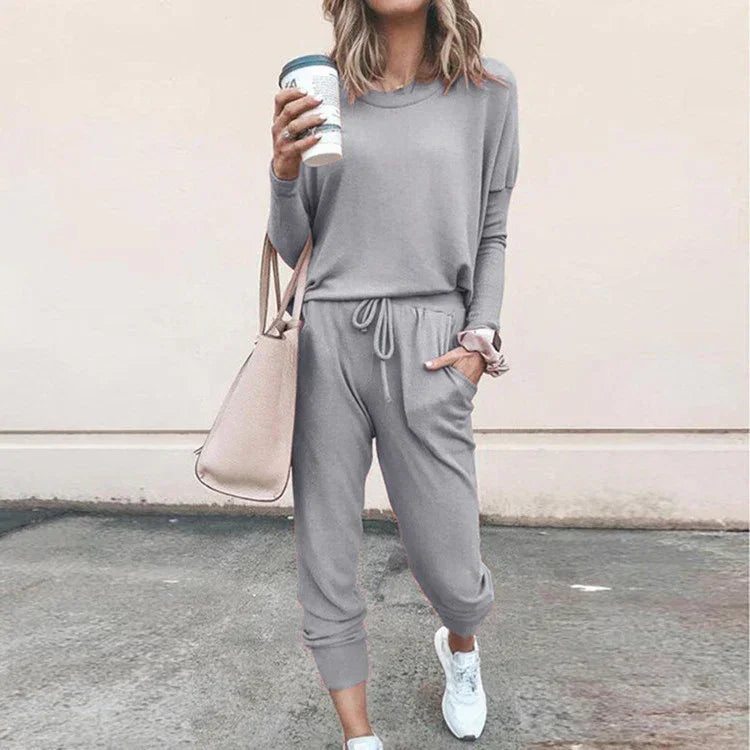 Woman in a light gray casual loungewear set with jogger pants, relaxed fit, soft fabric.