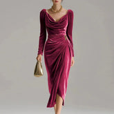 Woman wearing a long-sleeve velvet midi dress in deep pink with draped neckline and ruched waist