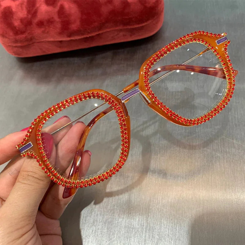 Oversized square eyeglasses with orange translucent frame and red rhinestone embellishments