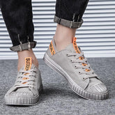 Light gray canvas low-top sneakers with orange text accents, rubber sole, streetwear style