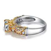 Gold and silver ring with intricate filigree, encrusted with clear gemstones and large center stone