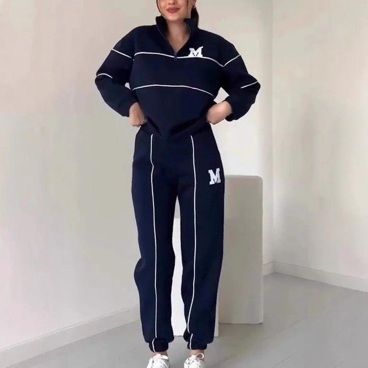 Woman wearing navy blue tracksuit set with white piping and relaxed fit, casual streetwear style