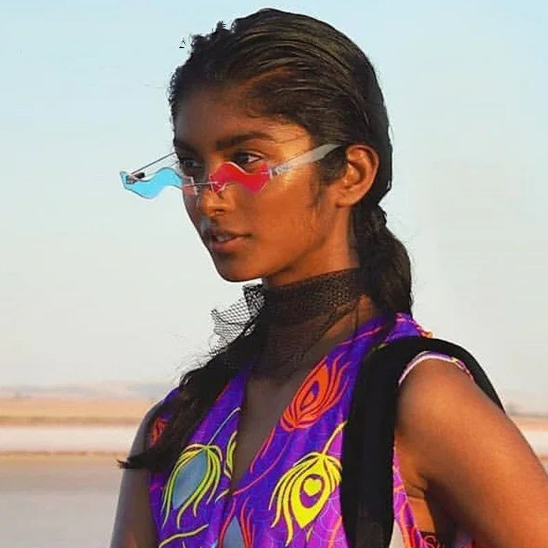 Woman in colorful sleeveless streetwear vest with peacock feather print, mesh choker, and futuristic heart-shaped sunglasses