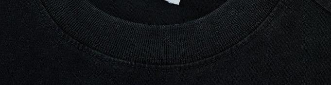 Close-up of black cotton crewneck sweatshirt with ribbed collar, relaxed fit