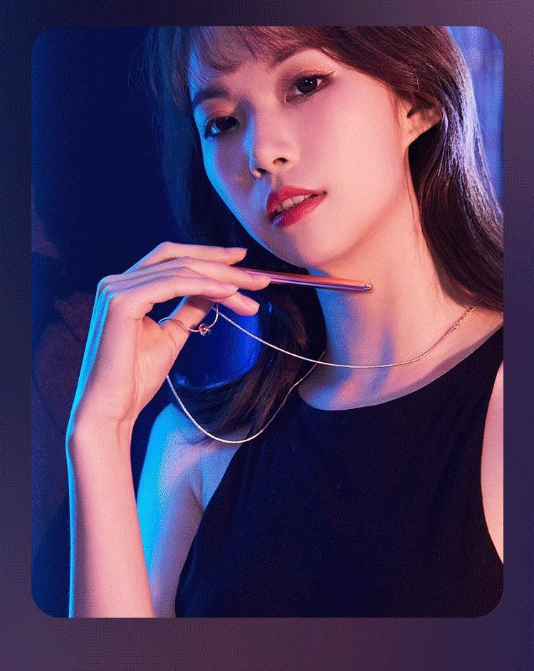 Woman in a sleeveless black top with a slim metallic necklace, futuristic lighting