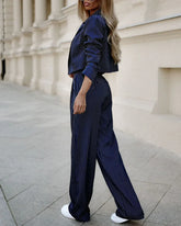 Woman wearing navy pinstripe pantsuit with wide-leg trousers and cropped blazer, relaxed fit