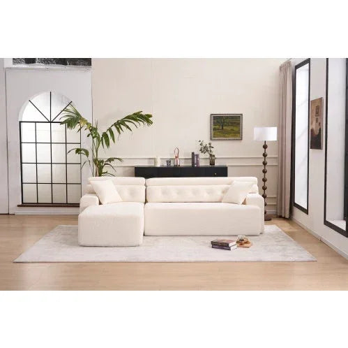 Modern living room with a cream tufted sofa, plush upholstery, and relaxed fit