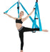 Woman in black athletic crop top and leggings doing aerial yoga with blue hammock, slim fit activewear.