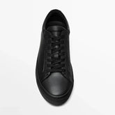 Minimalist black leather sneaker with lace-up design and low-top fit on white background