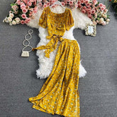 Yellow floral print two-piece set with short puff sleeve crop top and wide leg pants, soft flowy fabric.