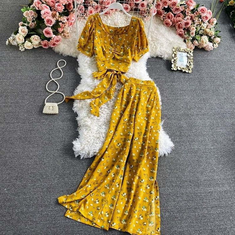 Yellow floral print two-piece set with short puff sleeve crop top and wide leg pants, soft flowy fabric.