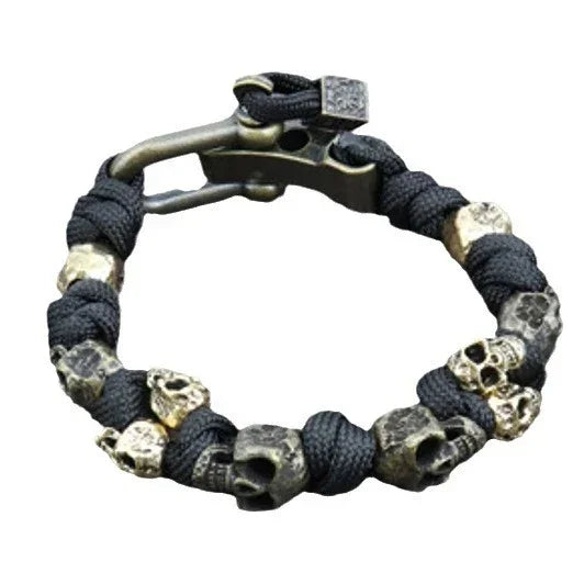 Black woven paracord bracelet with metallic skull beads, adjustable streetwear accessory.