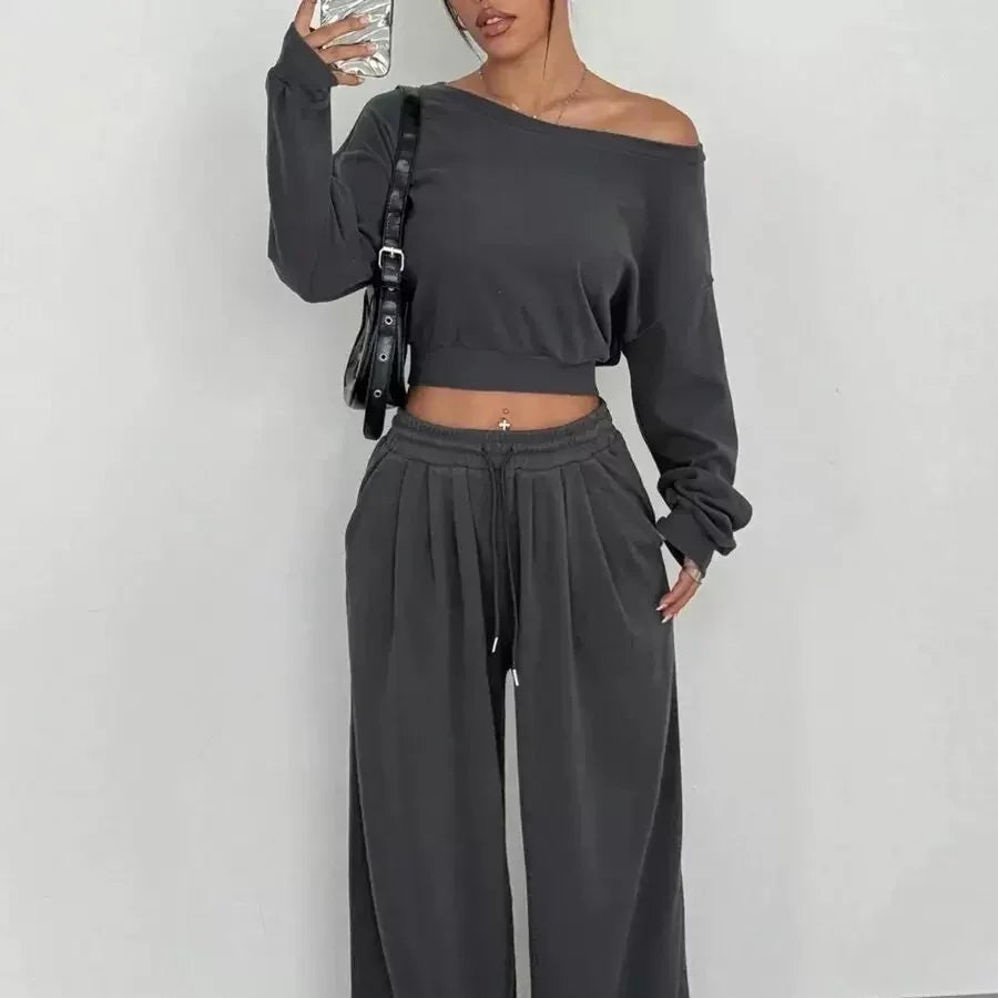 Woman wearing loose black off-shoulder crop top and wide-leg sweatpants set, casual fit