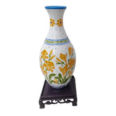 White puzzle vase with yellow floral pattern on dark wooden stand