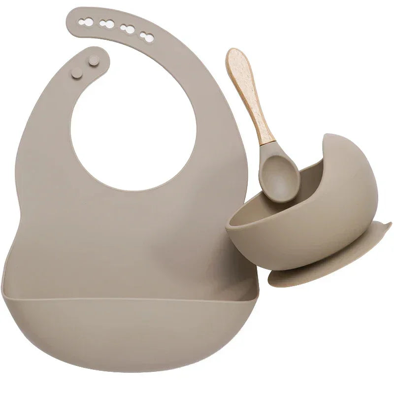Beige silicone baby bib, bowl, and spoon set with adjustable fit and modern style