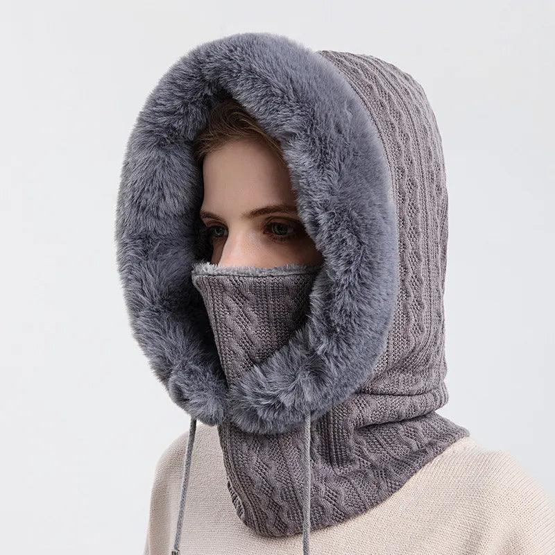 Woman wearing a thick grey knit hood with faux fur lining and matching face cover, winter streetwear.