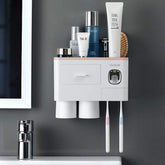 Wall-mounted white plastic bathroom organizer with cups and compartments, holding toiletries and toothbrushes