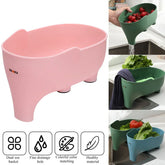 Plastic pig-shaped kitchen colander basket in pink and green, with drainage holes, for washing vegetables.