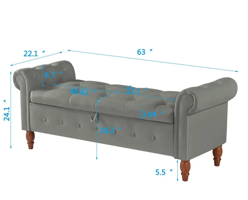Gray upholstered bench with tufted seat, rolled arms, wooden legs, and size measurements.