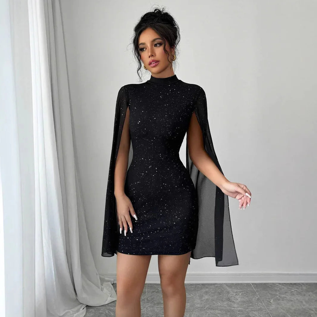 Woman wearing a fitted black sequin mini dress with sheer cape sleeves, modern streetwear style