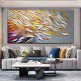 Modern living room with light gray sectional sofa, colorful abstract wall art, and velvet throw pillows.