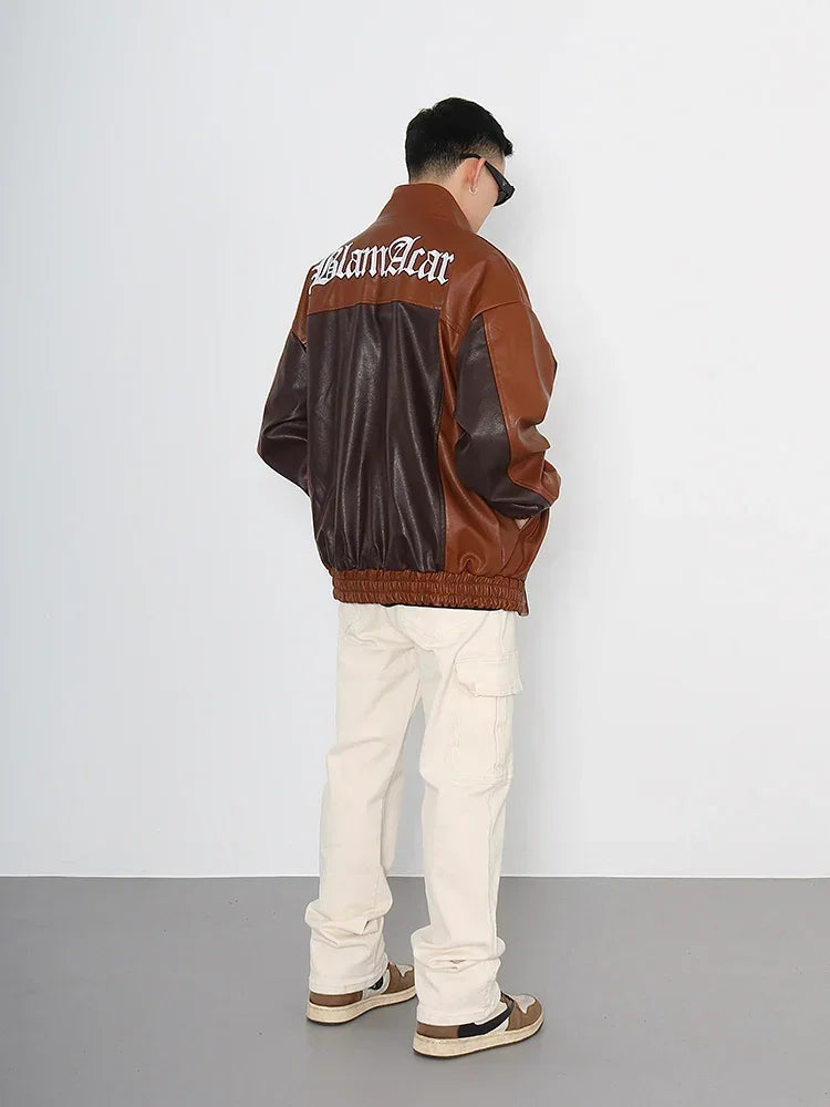 Man wearing a loose brown and dark brown faux leather jacket with lettering, ivory cargo pants, and sneakers