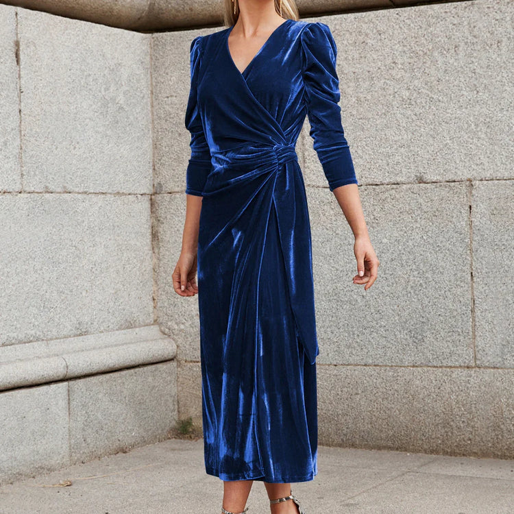 Woman wearing a royal blue velvet wrap midi dress with long sleeves and gathered waist