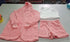 Pink sherpa hoodie, matching drawstring shorts, and a white fuzzy tank top set on table