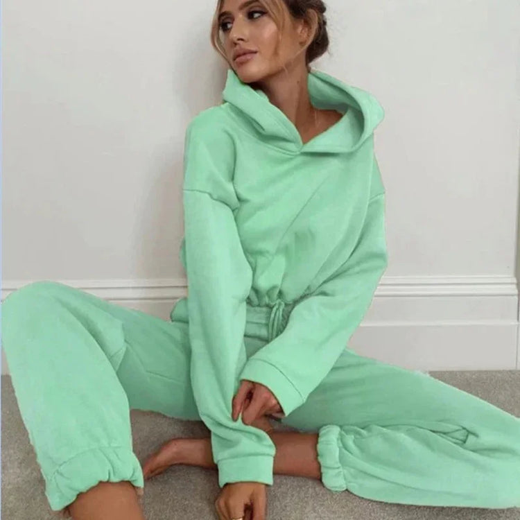 Woman in mint green fleece lounge set with relaxed fit and drawstring waist, sitting indoors