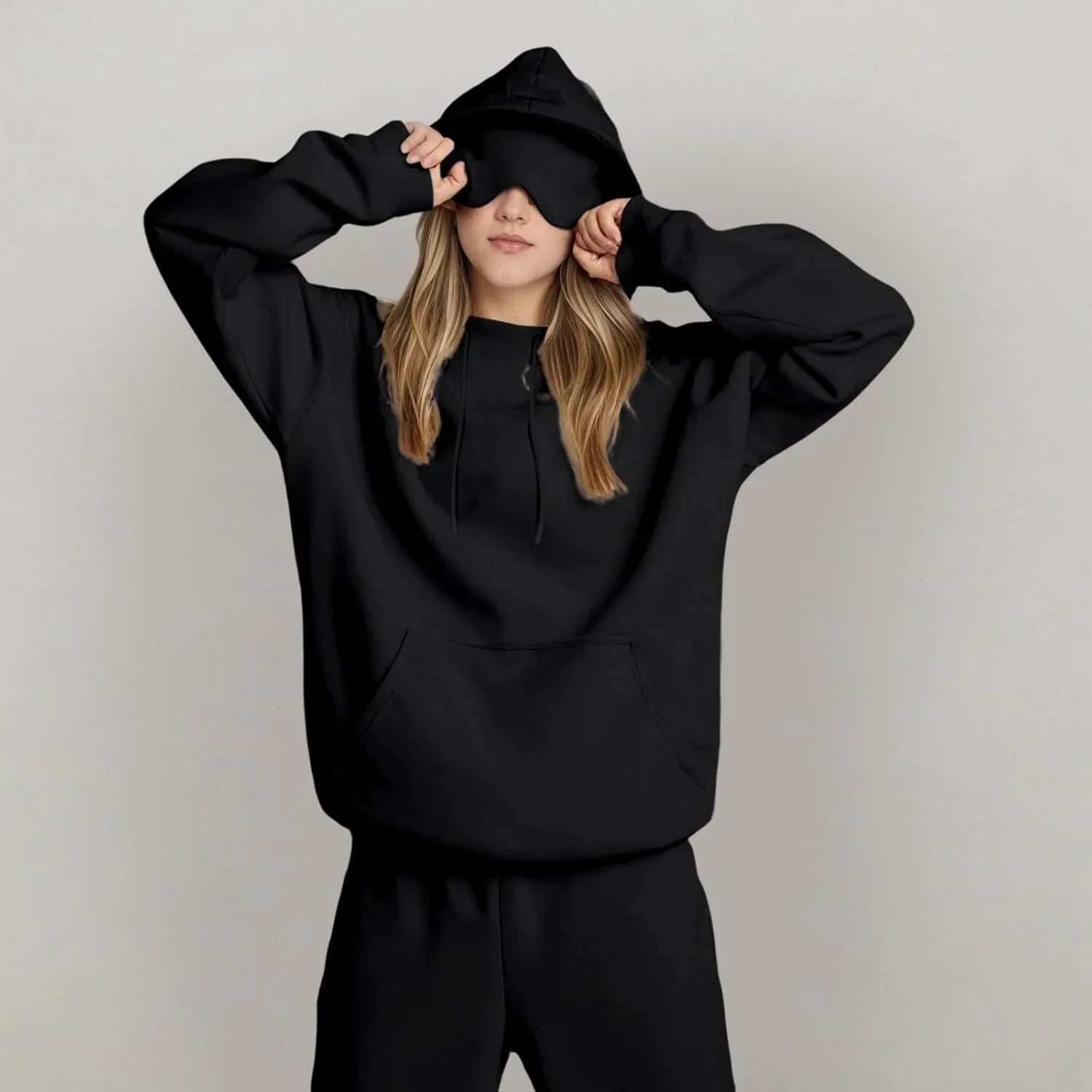 Woman in oversized black hoodie and sweatpants set, soft material, relaxed fit