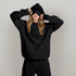 Woman in oversized black hoodie and sweatpants set, soft material, relaxed fit