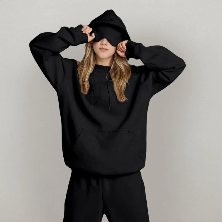 Woman in oversized black hoodie and sweatpants set, soft material, relaxed fit