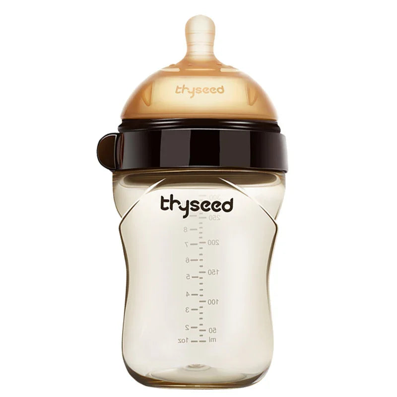 Tan and black baby bottle with silicone nipple, measurement markings, and ergonomic shape.