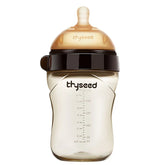 Tan and black baby bottle with silicone nipple, measurement markings, and ergonomic shape.