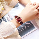 Woman wearing a red leather strap watch with a glossy red dial and gold case