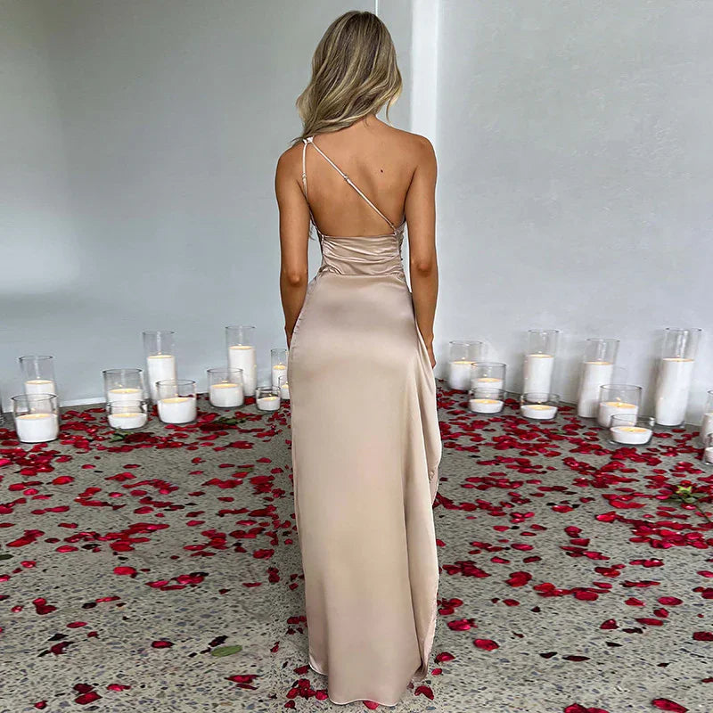 Woman in beige satin backless gown with slim fit, rose petals and candles on floor